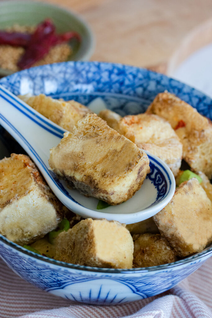 Air fryer salt and pepper tofu on a spoon.