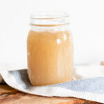 Pork bone broth in a glass container.