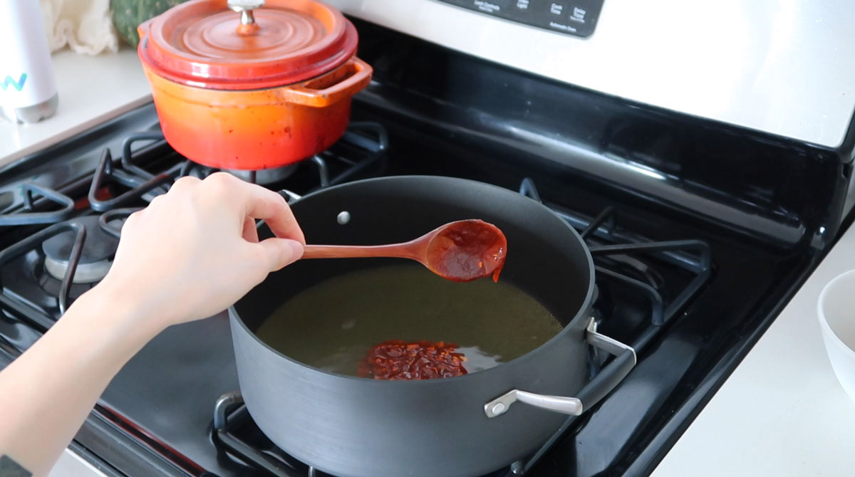 adding spicy paste to broth