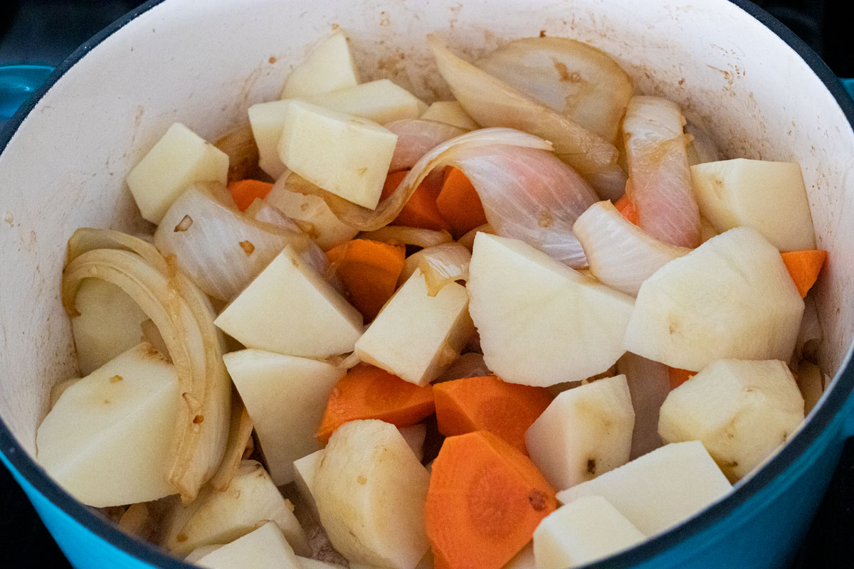 Potatoes, carrots, onions and mushrooms in a dutch oven.