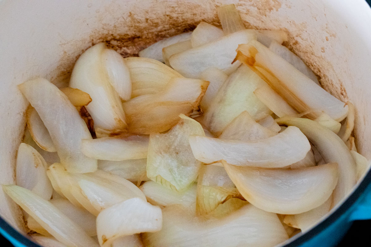 Slices onions in dutch oven.