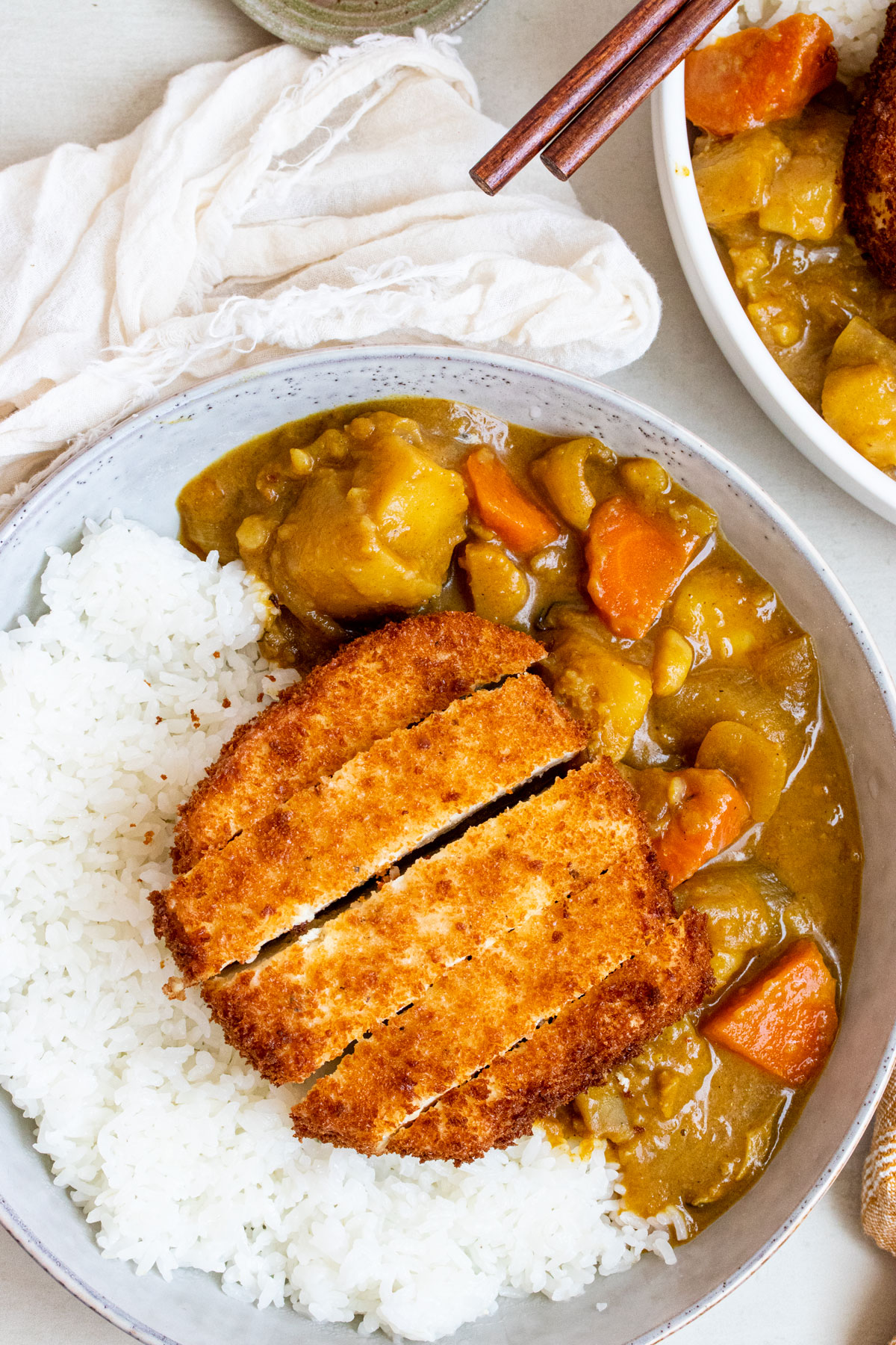 Fried tofu katsu over a bowl of Japanese curry and white rice.