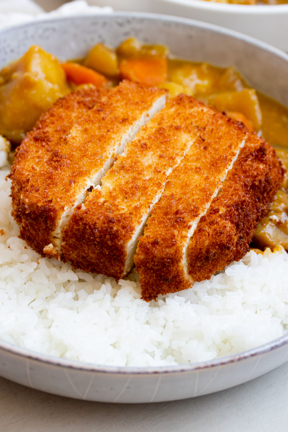 Tofu katsu over a bed of rice. 