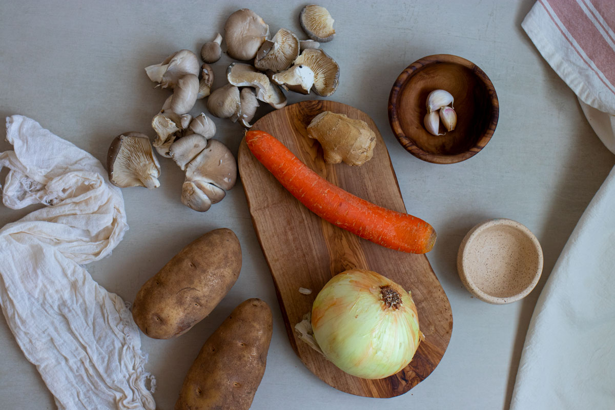 Ingredients for vegetarian Japanese curry including onion, carrots, garlic, mushrooms, and potatoes.