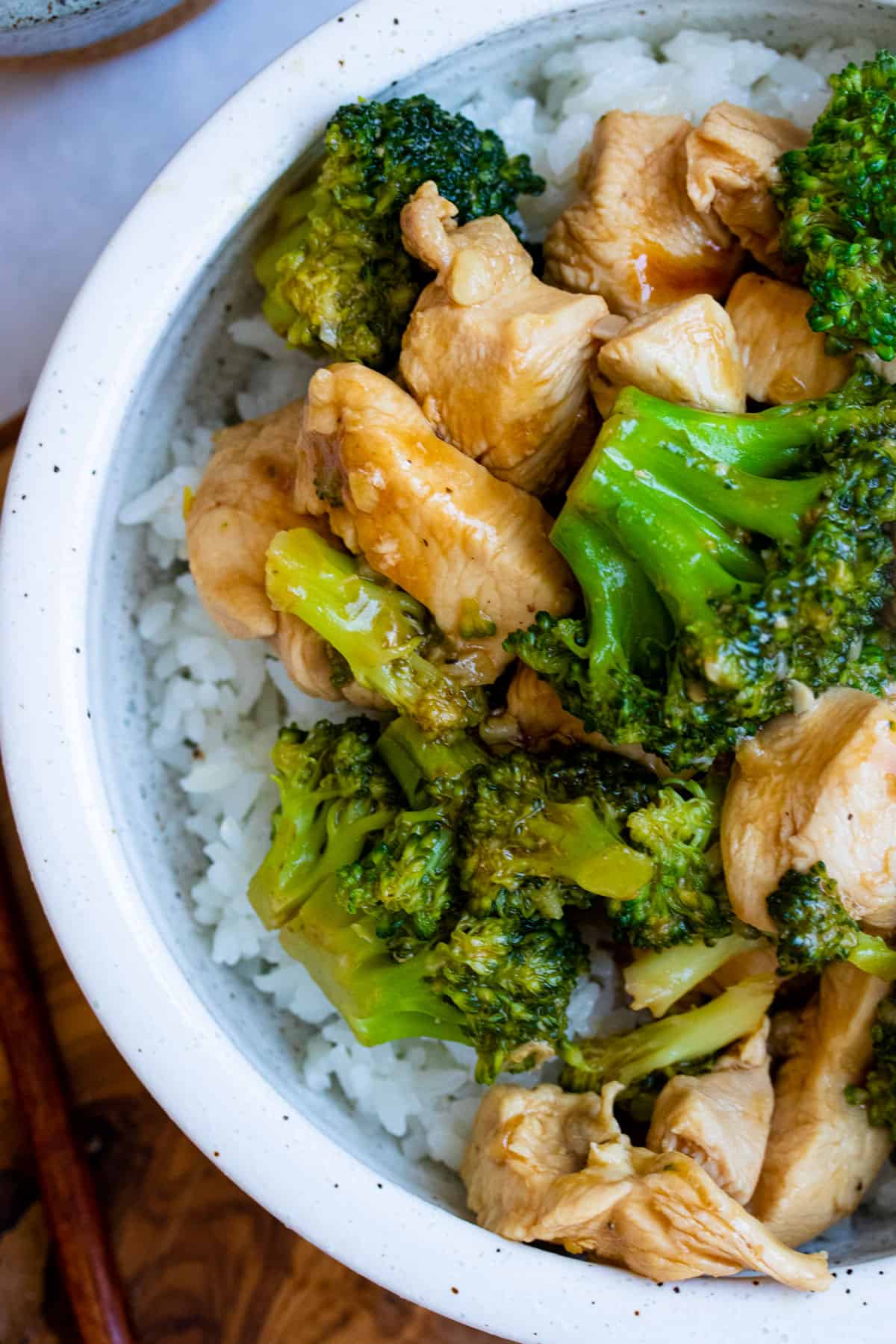 Chinese chicken and broccoli over a bowl of rice.