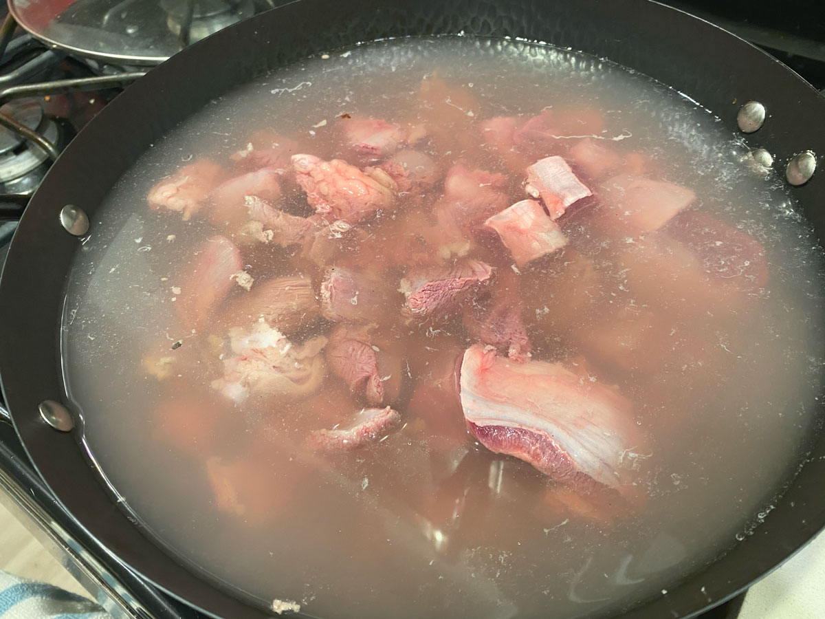 Boiling beef in pot.