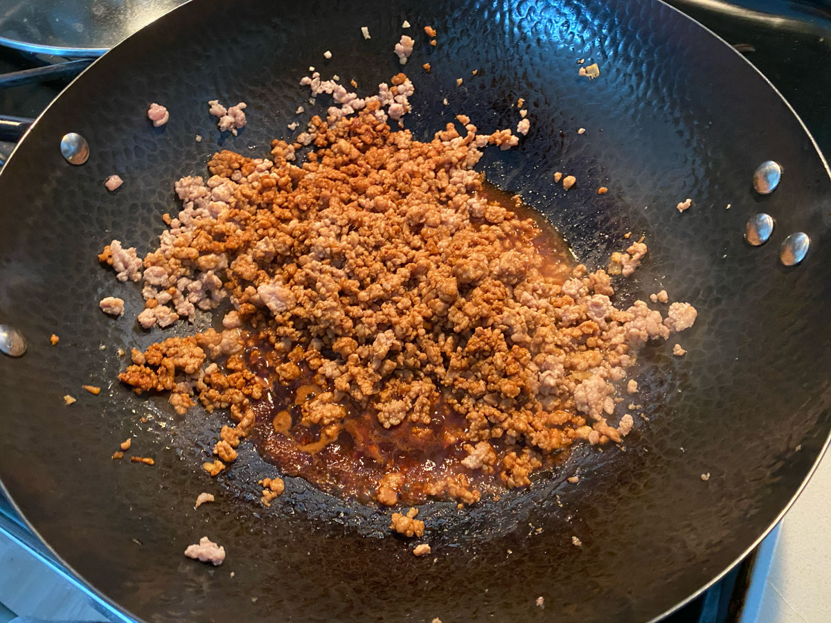 Cooking pork in wok.