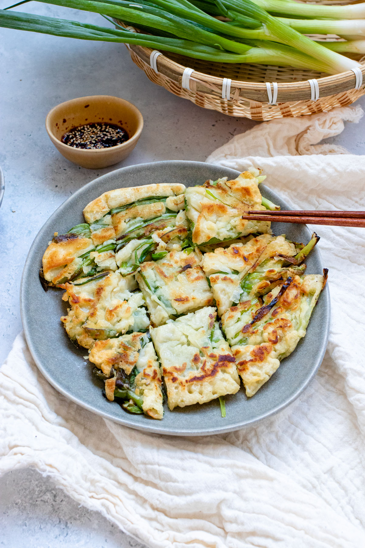 Korean scallion pancakes served on a plate with chopsticks.