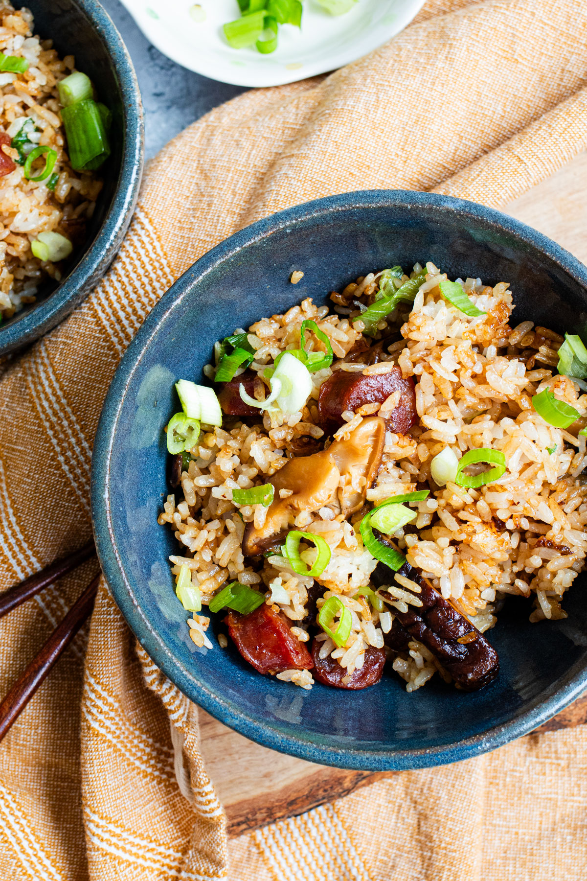 Chinese sausage rice with shiitake mushrooms in a blue bowl.