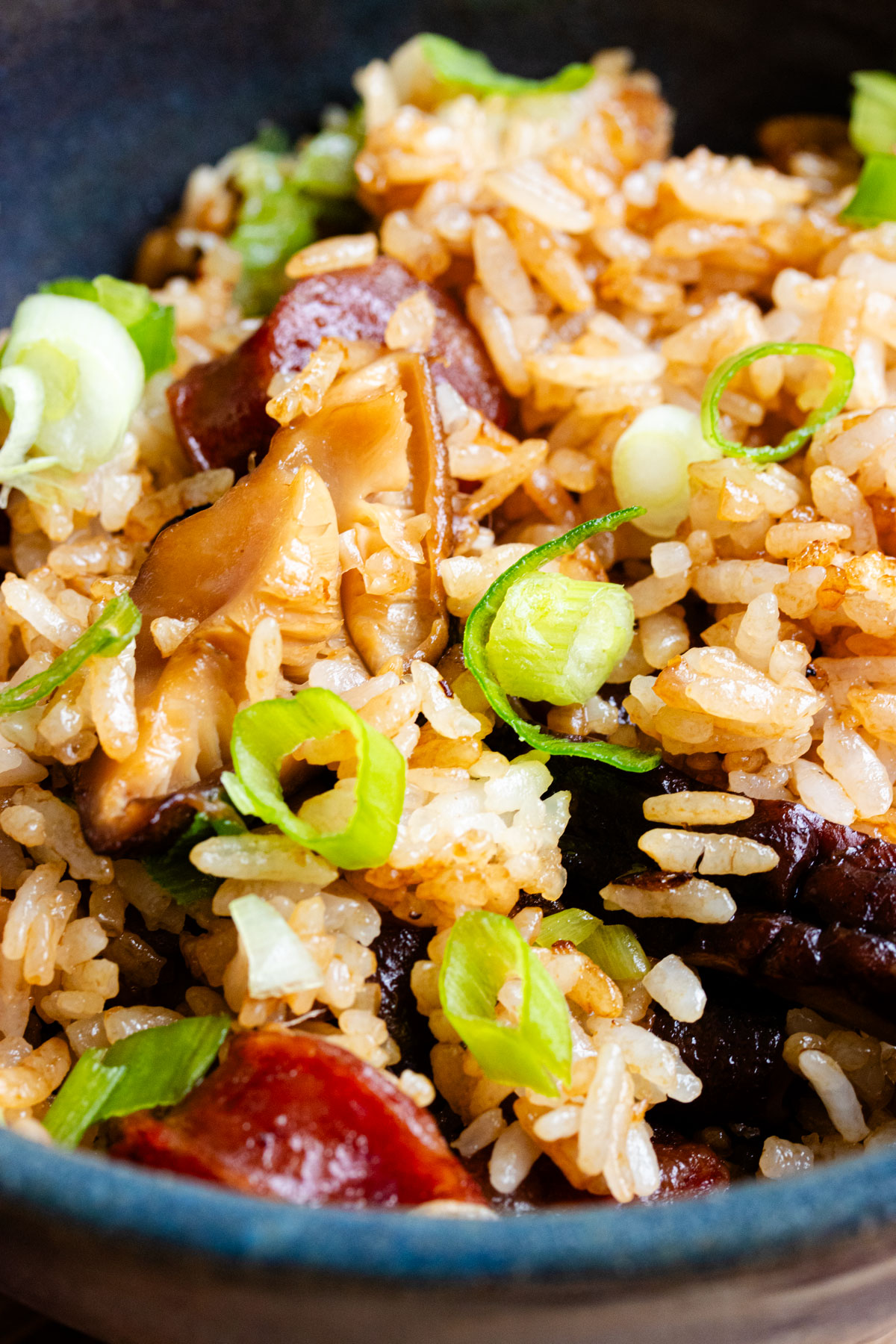 Chinese sausage rice with mushrooms and scallions.