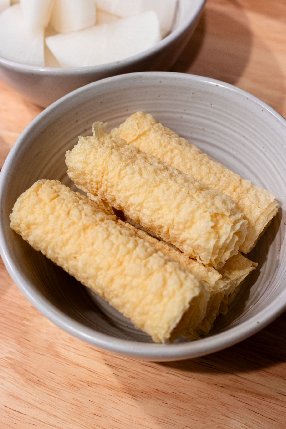 Fried tofu rolls in bowl.