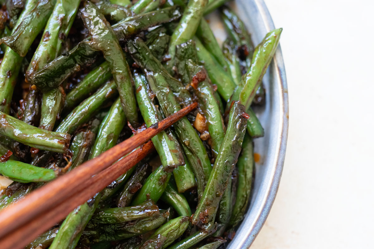 Chinese stir-fry green beans with chopsticks.