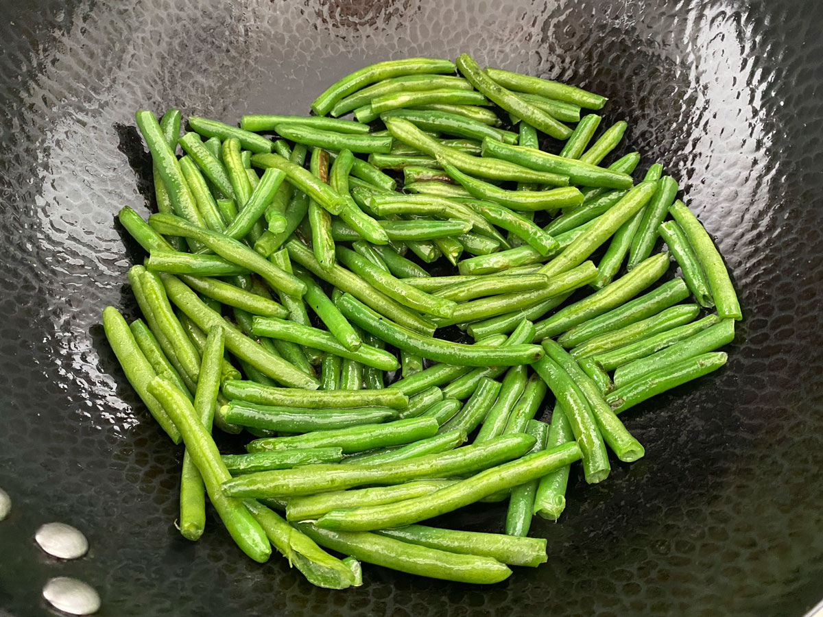 Green beans cooking in wok.