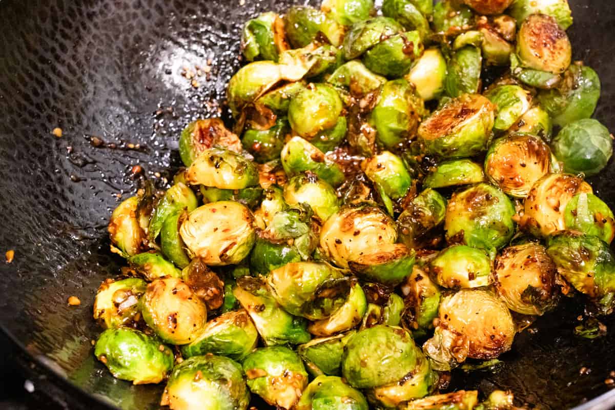 Brussels sprouts in wok tossed with kung pao sauce.