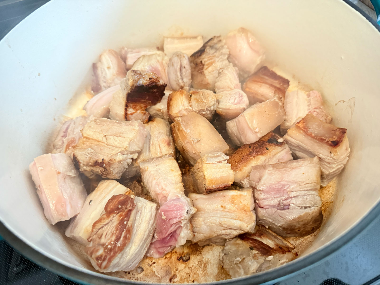 Sear sliced pork belly in hot pan.